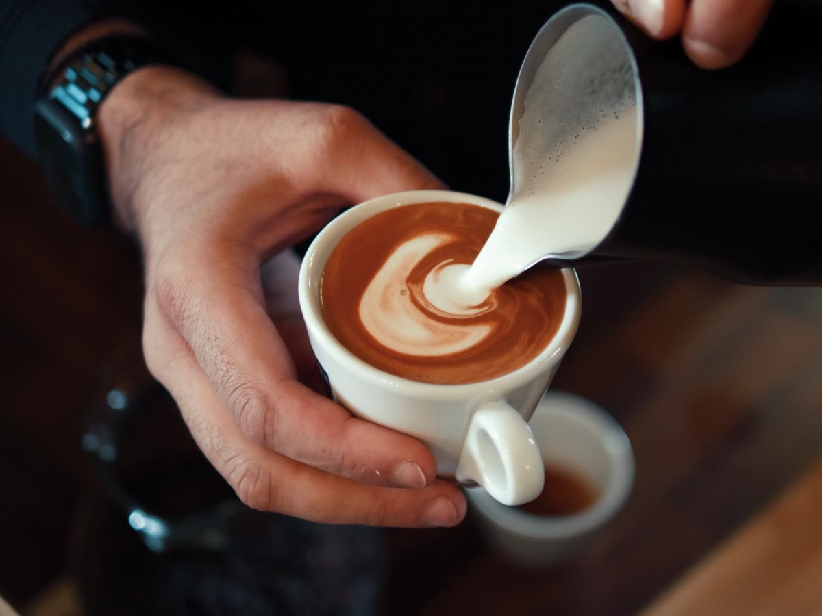 Steamed milk being poured into a latte